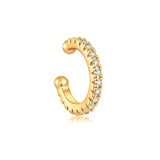 Gold ear cuff with shimmering pavé stones in a minimal curved design on a white background